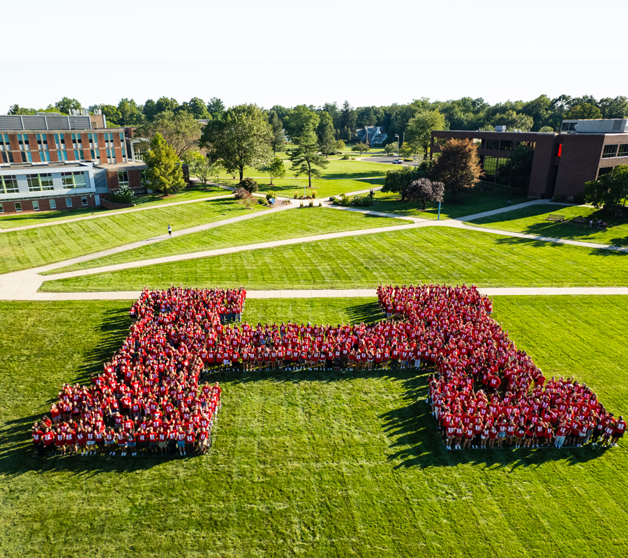 students forming human H on campus lawn
