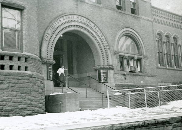 Old image of UHart building exterior with a student leaving the building
