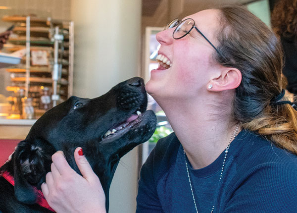 Teddy, UHart's comfort dog shows love to a student