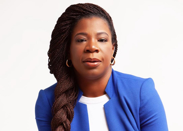 Headshot of Sylvia Ofori-Boadu, founder of You Emerge Coaching, smiling and wearing a blazer.