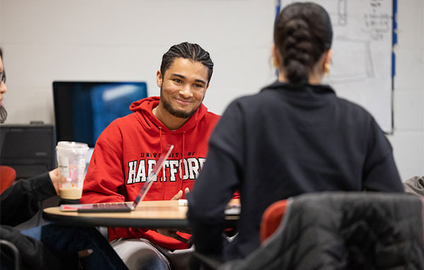 Current student listening to a fellow student talk in class.
