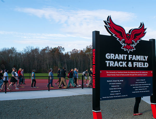 track sign with people walking by
