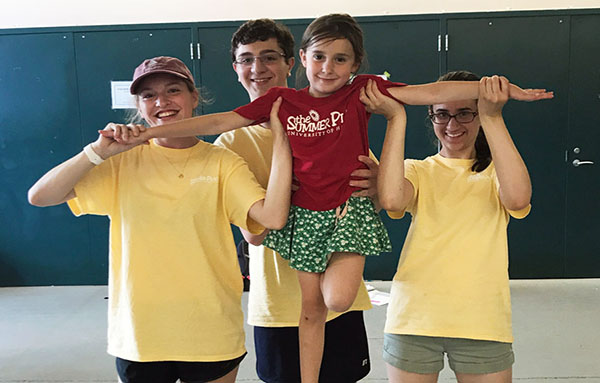 Leaders in training posing with camper