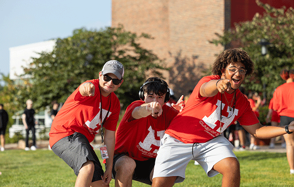 students pointing to the camera