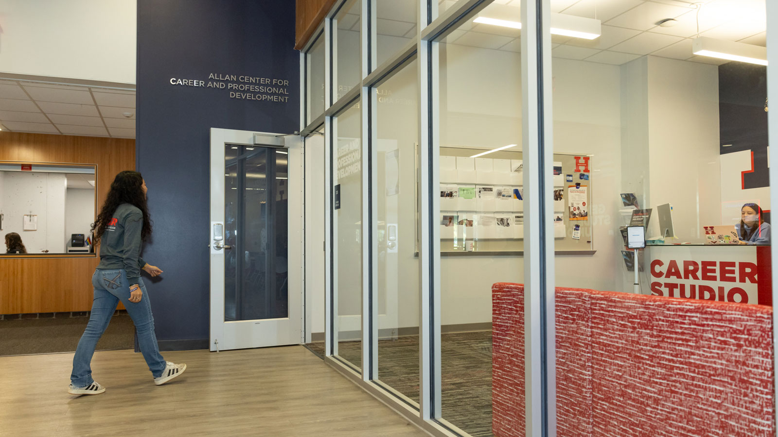 A University of Hartford student walking into the Allen Center doorway.