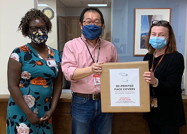 three people standing with box