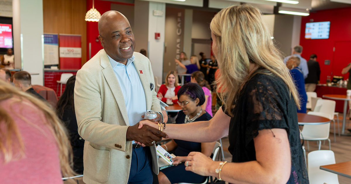 President Ward shaking hands of industry partner on campus.
