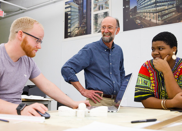 two students with a professor of architecture