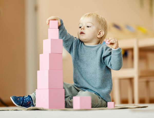 Montessori primary student working on the Pink Tower.