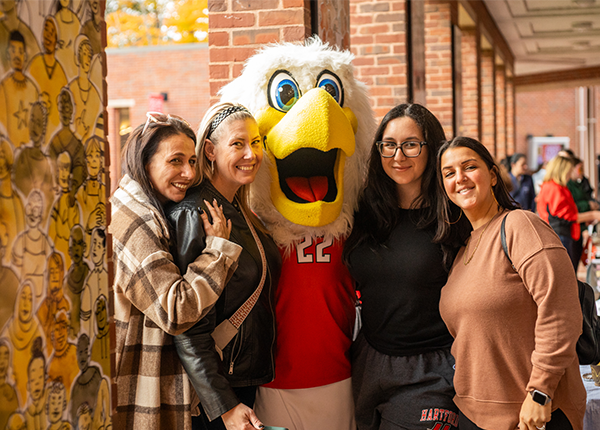 students standing with Uhart Hawk Mascot